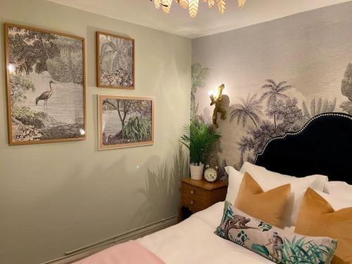 sypialnia z łóżkiem i obrazami na ścianie w obiekcie Stylish Apartment in Leafy Ealing w mieście Ealing