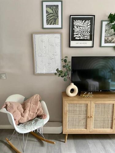 a living room with a television and a chair at Stylish Apartment in Leafy Ealing in Ealing