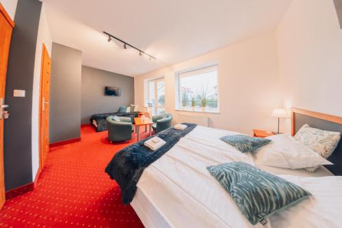 sypialnia z dużym łóżkiem i czerwonym dywanem w obiekcie Willa Szafir w Kołobrzegu