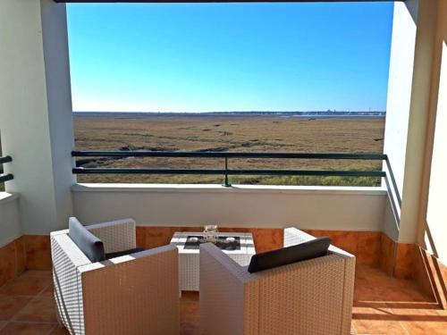 イスラ・カネラにあるLas Marismas de Isla Canelaの大きな窓とテーブルと椅子のある部屋