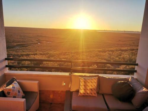 イスラ・カネラにあるLas Marismas de Isla Canelaの夕日を望むバルコニー(ソファ付)