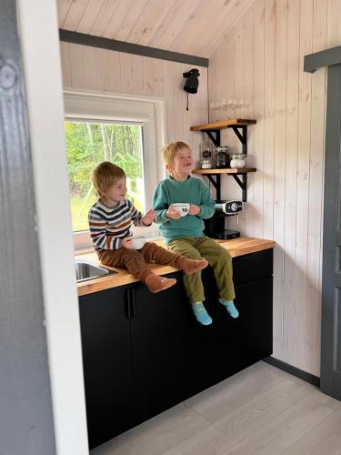 two young boys sitting on a counter in a kitchen at Pussala Latgalē 