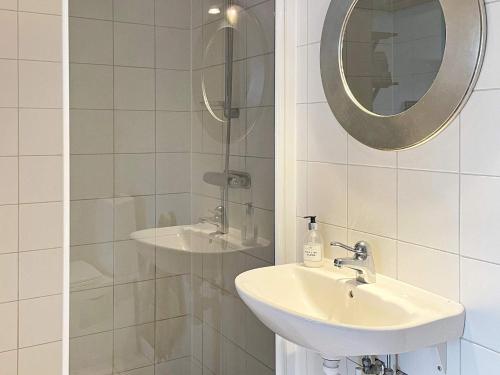 uma casa de banho branca com um lavatório e um espelho em Holiday home Onsala IV em Onsala