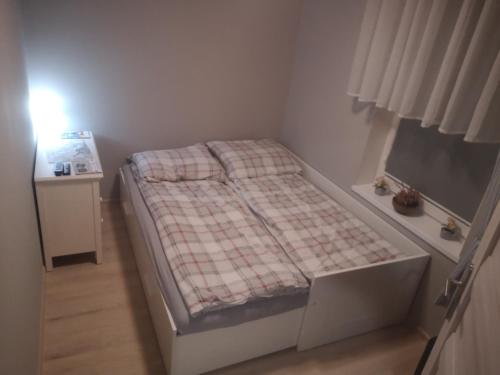 a small bedroom with a bed with a plaid blanket at Apartament exclusive Głuszyca in Głuszyca
