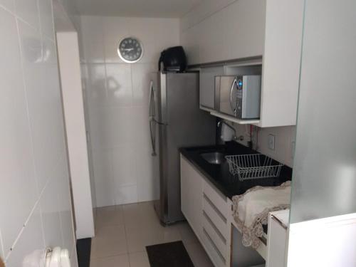 une petite cuisine avec un réfrigérateur et un micro-ondes dans l'établissement Apto Ventano, à Campos dos Goytacazes