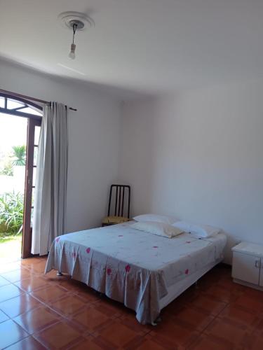 1 dormitorio con 1 cama en una habitación con ventana en Casa no Campeche em ambiente familiar, en Florianópolis