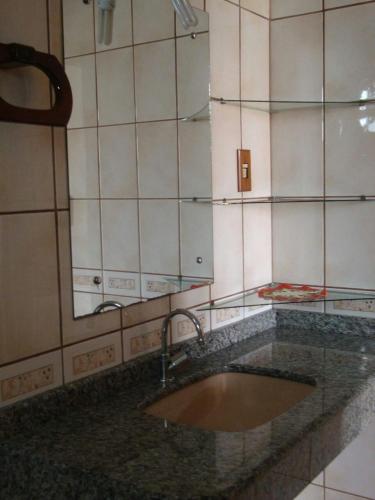 encimera con lavabo y espejo en Casa no Campeche em ambiente familiar, en Florianópolis