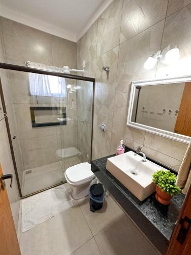 a bathroom with a sink and a shower and a toilet at Casa Dos Papagaios in Bonito