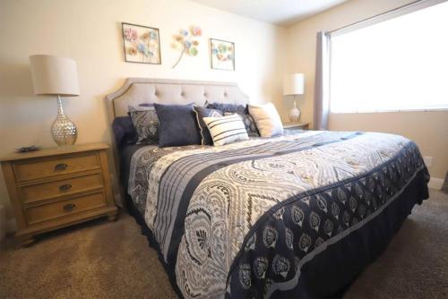 a bedroom with a bed with a blue and white comforter at Cactus Rose Villa with 2 Pools 2 Spas Gym in Washington
