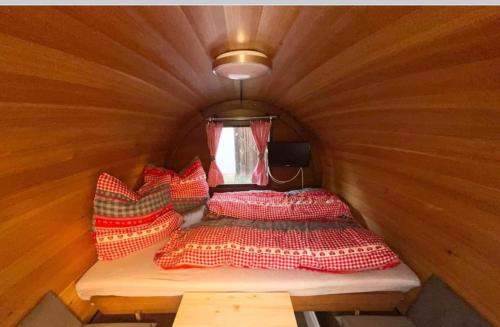 een kleine kamer met een bed en kussens in een tent bij Schlafen im Weinfass in Ipsheim