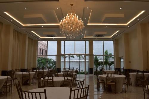 a banquet hall with tables and chairs and a chandelier at The White Lotus in Gaya