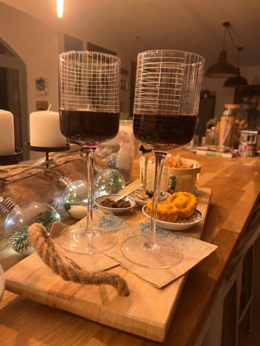 dos copas de vino sentadas en una mesa de madera en Suite partner, en Peyriac-Minervois