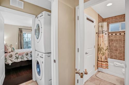 a bathroom with a washer and dryer next to a bedroom at Inviting waterfront cottage with balcony, firepit, marsh views, & washer/dryer in Fernandina Beach