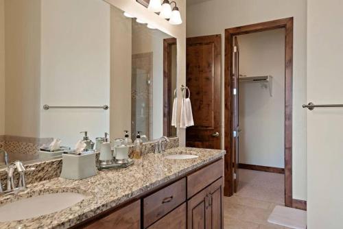 Un baño con dos lavabos y un espejo grande. en Copper Giraffe Enjoy Golden Golf Course Views, en Washington