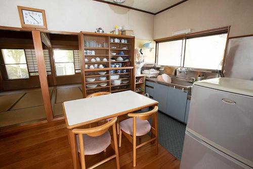 a kitchen with a table and chairs and a refrigerator at Guest House Oni no Sanpo Michi - Vacation STAY 40084v in Kumano