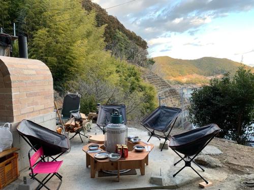 a patio with chairs and a table with a stove at Guest House Oni no Sanpo Michi - Vacation STAY 40084v in Kumano