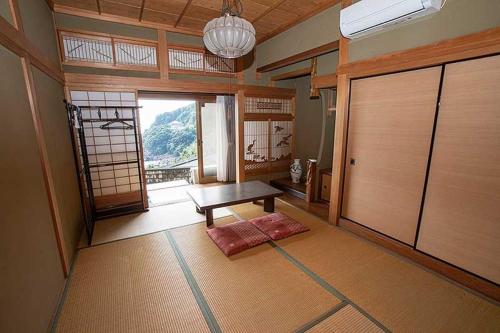a room with a table and a door with a window at Guest House Oni no Sanpo Michi - Vacation STAY 40084v in Kumano