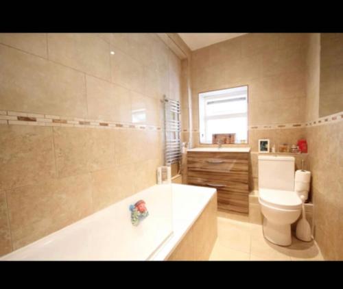 een badkamer met een bad, een toilet en een wastafel bij Fab location 2 bed garden flat camden in Londen