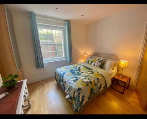 a bedroom with a bed and a window at Fab location 2 bed garden flat camden in London