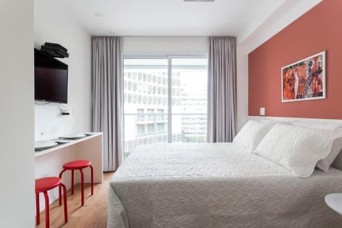 a hotel room with a bed and a large window at Loft Moderno, Andar Alto #1106 in Sao Paulo