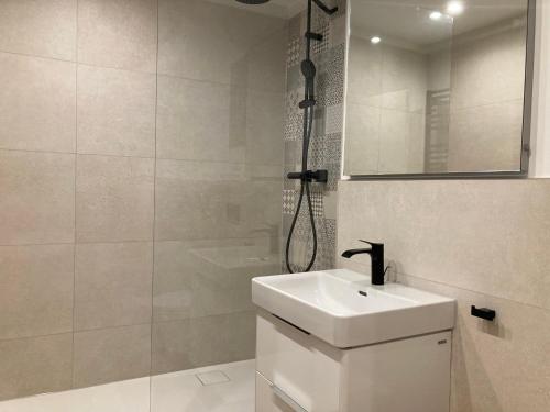 a white bathroom with a sink and a shower at PATAMA Karli Suite - Zentrales City-Feeling nahe Südvorstadt, Uniklinik in Leipzig