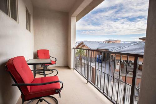 a balcony with two chairs and a table on it at Zion Village Oasis by the Pool with Lazy River in Hurricane