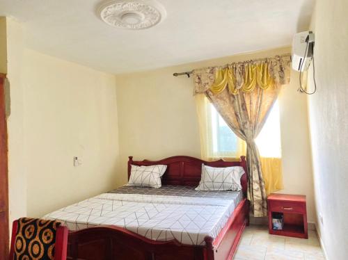 a bedroom with a bed and a window at APEX ANNEX Guest Facility in Buea