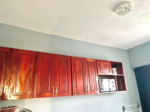 a kitchen with wooden cabinets and a white ceiling at APEX ANNEX Guest Facility in Buea