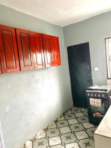 a kitchen with red cabinets and a stove at APEX ANNEX Guest Facility in Buea
