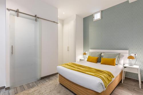 1 dormitorio con 1 cama grande con almohadas amarillas en BNBHolder Relishing LA GRAN VIA, en Madrid