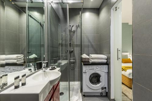 y baño con lavabo y lavadora. en BNBHolder Relishing LA GRAN VIA, en Madrid