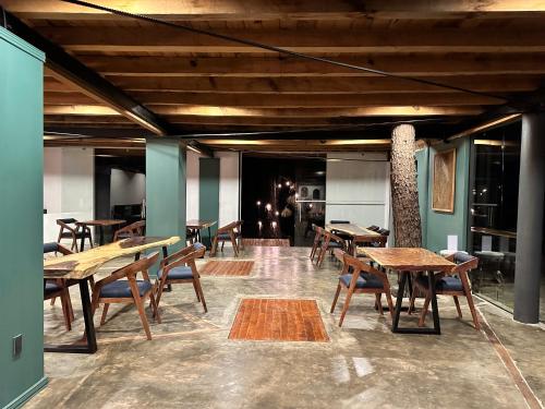a restaurant with wooden tables and chairs in a room at PINE TREE Mazamitla Hotel Boutique & Cabañas in Mazamitla