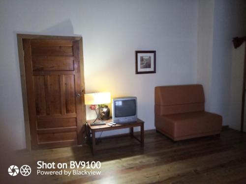 a room with a door and a chair and a television at Casa del Campo in Tela