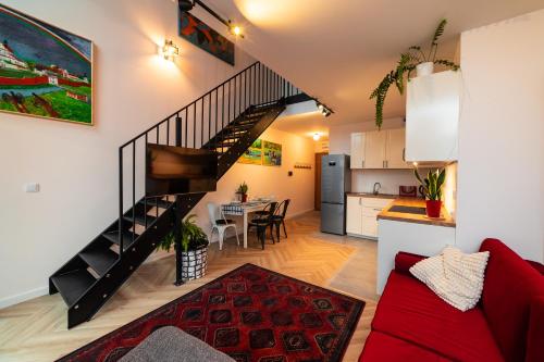 sala de estar y cocina con escalera de caracol en Apartament Mazagran en Zamość