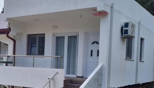 a white house with a door and a balcony at Apartment AS in Čanj