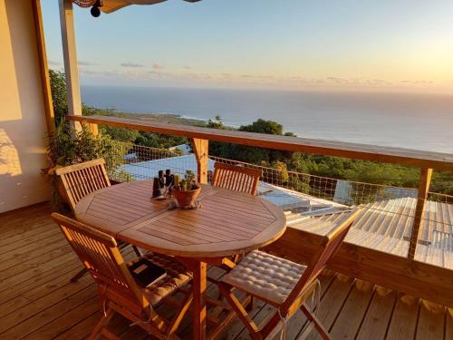 - une table et des chaises sur une terrasse avec vue sur l'océan dans l'établissement Le Noé, à Saint-Leu