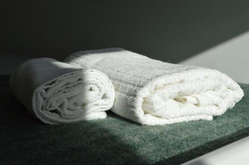een handdoek bovenop een groene handdoek bij Centro Rewilding 