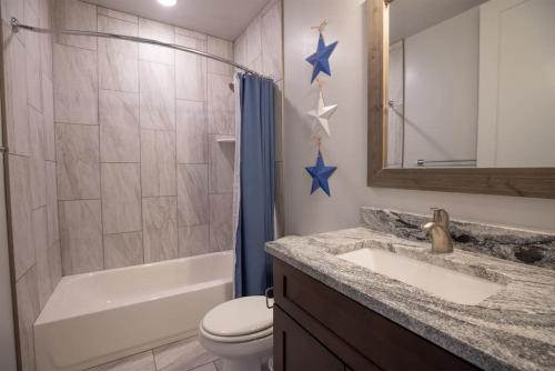 La salle de bains est pourvue d'un lavabo, de toilettes et d'une douche. dans l'établissement The Americana Private Spa and Trailer Parking, à Hurricane