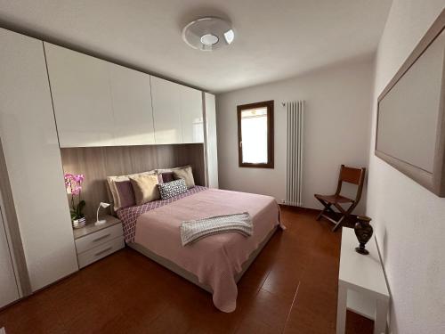 1 dormitorio con 1 cama y 1 silla en B&B Codivilla 67, en Lagune