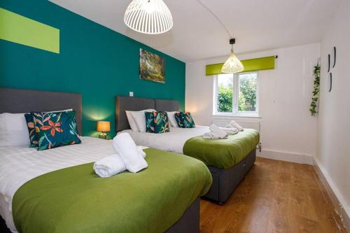 two beds in a room with blue and green walls at *New*Quiet Apt 13min to AO Arena,Free Parking in Manchester