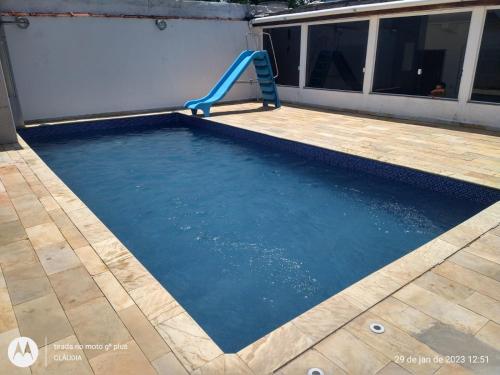 a plunge pool with a slide in a house at Casa com piscina aconchegante e relaxante in Mongaguá