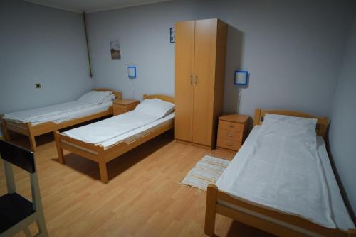 a room with two beds and a cabinet at Vila Balkan in Kikinda