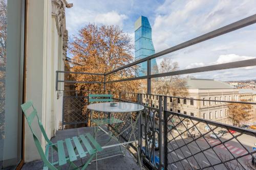 a balcony with a table and chairs and a building at Alma Boutique Hotel in Tbilisi City
