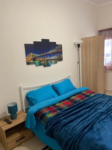 - une chambre avec un lit doté de draps bleus et d'un pont dans l'établissement Ifos Apartments, à Thessalonique
