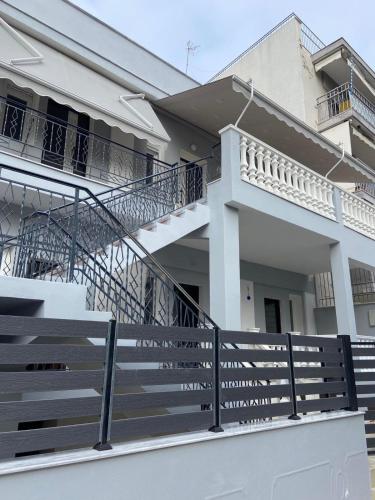 une maison blanche avec des escaliers et un balcon. dans l'établissement Ifos Apartments, à Thessalonique
