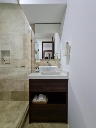 a bathroom with a sink and a shower at Modernos Estudios a pasos De La 5ta Av Pool view - By Yeah in Playa del Carmen