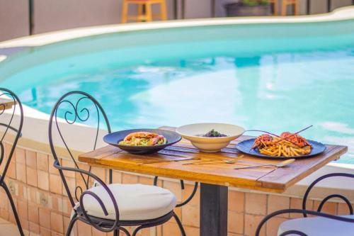 a table with plates of food on it next to a pool at Hotel Lumbarda in Lumbarda