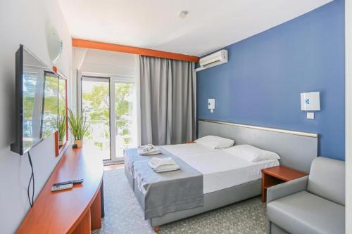 um quarto de hotel com uma cama e uma parede azul em Hotel Lumbarda em Lumbarda
