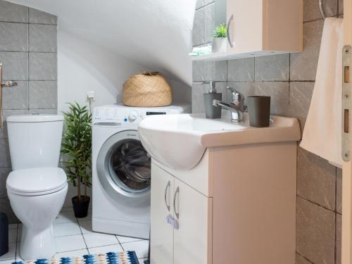 a bathroom with a sink and a washing machine at Euphoria Country House in Agios Ioannis