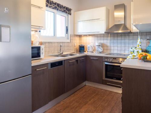 a kitchen with brown cabinets and a sink at Euphoria Country House in Agios Ioannis